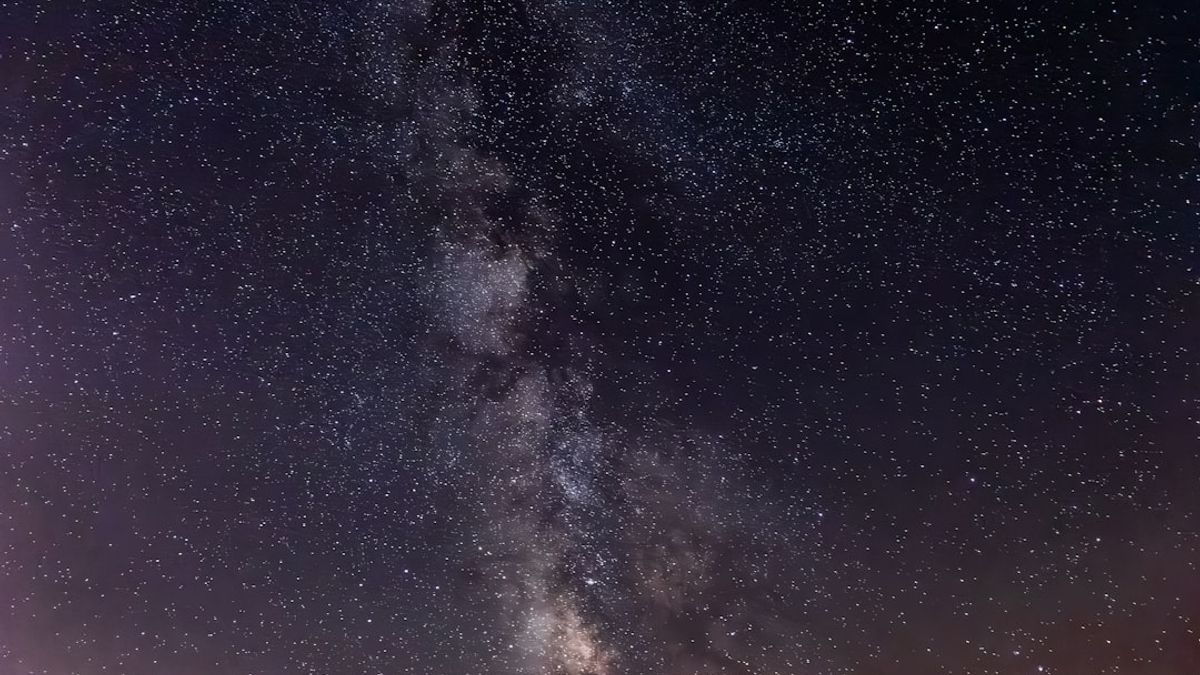 Um jantar requintado sendo servido sob um céu estrelado, com um telescópio ao fundo, criando uma atmosfera mágica e inesquecível.